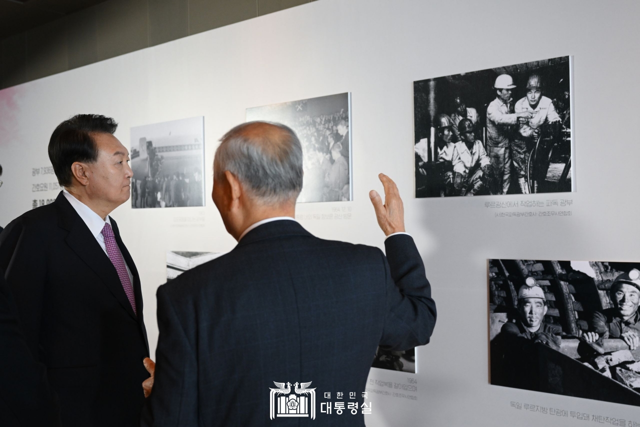 윤 대통령이 10월 4일 서울 워커힐호텔에서 개최한 파독 근로 60주년 기념 오찬에 앞서 파독 광부들의 사진을 보고 있다.