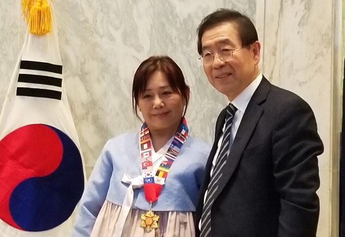 박원순 시장이 김미실 회장에게 ‘정전 기념 메달’을 수여했다.<br>