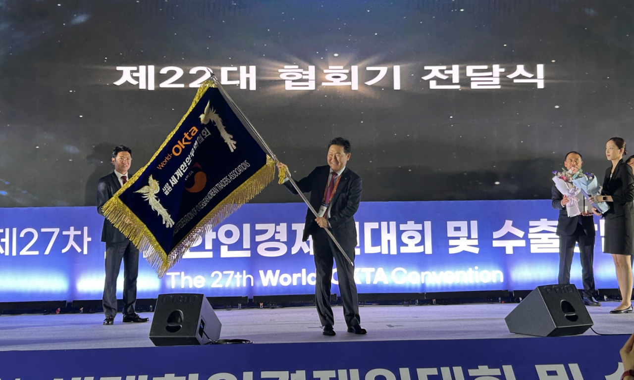 신임 이사장으로 선출된 박종범 영산그룹 회장이 세계한인무역협회 깃발을 전달받았다.